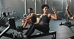 People, rowing machine and gym exercise with high five for cardio workout or fitness teamwork, friends or support. Men, woman and healthy training for sport together as athlete, wellness or challenge