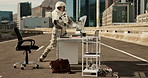Destroy, tech and apocalypse with astronaut suit with protection from nuclear pollution. Angry, break and technology breakdown and ruin after disaster on earth in a isolated city street with desk  
