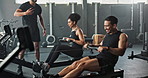Workout, rowing machine and instructor with group in gym for wellness, sports or body health. Coach, club and people exercise on ergometer for fitness, muscle and cross training for cardio with pain