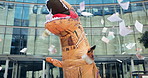 Mascot, dance and city with money rain, urban office building and documents for work. Costume, inflatable dinosaur and fun for entertainment, company culture and prank with funny business joke