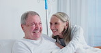 Senior, conversation and happy couple in hospital bed for visit, support and laugh together at funny story with sick husband. Smile, man. and woman talking in clinic for wellness, medical or health