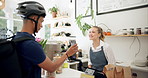 Phone, barista or delivery man in coffee shop or cafe for drinks, food or package at checkout counter in a store. Courier app, bicycle helmet or waitress in small business with a mobile, woman or guy
