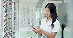 Glasses, shop and woman cleaning lenses with cloth for vision, eyesight and designer frame. Eye care, optometry and sales assistant in store with prescription eyewear, display and solution for sight
