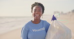 Beach, face or happy black woman with plastic bag for earth day, sustainability or ocean cleaning project. Recycle, sustainability and portrait of volunteer at sea for NGO, accountability or charity