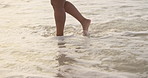 Feet, legs and walking into ocean with beach, vacation on tropical island with travel for peace and calm. Earth, water with journey and adventure outdoor, waves and sea shore with tourism for summer
