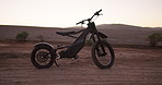 Desert, electric bike and sunset with extreme sports, challenge and competition with training and nature. Traveling, vehicle and outdoor with carbon footprint and eco friendly with sustainability
