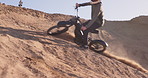 Sport, motorcycle and person driving in desert, sand and stunt on hill for challenge in performance. Dirt, trail and driver travel on motorbike with skill, technique and adventure in countryside