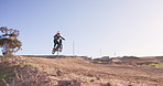 Motorcycle, stunt and man riding on off road for competition or race motorcross training. Dirtbike, fitness and male biker athlete practicing skill, sports or talent with speed for challenge.