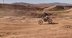 Motorcycle, speed and driver on sand trail with motorcross, power and rider outdoors. Man, motorbike and male person travel or riding on dirt track, performance and action or talent for freedom