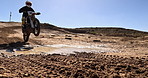 Sport, motorcycle and person driving off road in desert, sand with jump on hill or stunt on wheel. Dirt, trail and driver travel on motorbike with skill, technique and moto adventure in countryside