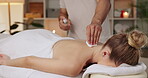Woman, back massage and oil in spa or prepare for pressure points treatment with spray bottle, knots or pain relief. Female person, masseuse and hands for relaxing muscle, chronic ache or benefits