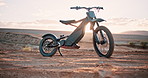 Sunset, desert and off road motorbike for transport, adventure and machine on dune for competition. Extreme sport, mountain bike or motorcycle on sand for challenge, power or race on dirt course.