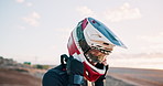 Outdoor, motorbike and man with a helmet, training and safety with extreme sports and practice with sand. Dune, sunshine and driver with protection and travel with cycling and energy with challenge