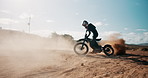 Biker, sand or person spinning motorbike in outdoor training and safety for extreme sports or practice in desert. Fun, dirt or driver on motorcycle for dunes, dust or donuts in performance on holiday
