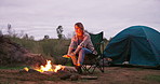 Fire, woman and camping wood with tent flames for heating hands and relax in nature on holiday. Adventure, field and rocks in a campsite with smoke, burning and pit with calm and eco travel in a park
