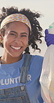 Woman, face and volunteer on beach with plastic bag for community service, environment or cleaning. Black person, wind and activist as earth day project or charity, waste management or climate change