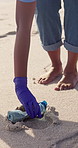 Volunteer, plastic and cleaning beach for pollution activism for community service, conservation or litter. Person, hands and global warming future with environment clean up, trash or eco friendly