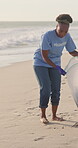 Volunteer, beach and cleaning garbage for pollution management, global warming or community service. Black person, activist and plastic bag for litter recycling at ocean, conservation or earth day