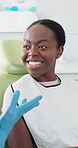 Appointment, smile and black woman talking to dentist in office for dental care or medical checkup. Healthcare, oral hygiene and patient with person in chair for consulting or teeth cleaning