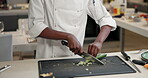 Person, hands and chef or chopping vegetables or cooking in industrial kitchen or cuisine, meal prep or professional. Knife, board and hospitality or customer service in restaurant, prepare or dinner