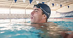 Man, breathing and tired from swimming in pool, exercise and fitness for sport. Male athlete, workout and recovery in water for health or wellness, strong with pause for cardio or aerobic training