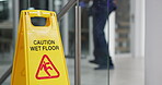 Person, mopping and office with caution sign, janitor and hygiene service and wet floor for healthcare. Attention, safety and warning for risk, dancing and cleaner happy for cleaning or maintenance