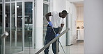 African man, cleaning and mopping office floor with earphones for work or company. Commercial cleaner, service and maintenance in workplace for sanitary environment, employees and staff with chemical