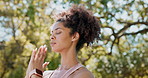 African woman, calm and yoga in nature for peace, healing and wellness with eyes closed and praying hands. Young person or yogi meditation, mindfulness and holistic health in forest, outdoor or park