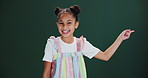 Kids, face and girl with hand pointing in studio for news, announcement or deal info on green background. Decision, menu or portrait of happy child model with finger choice for sale, offer or promo