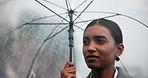 Indian woman, rain and walking with umbrella for business trip, travel or commute to work in winter season. Female person or employee strolling in neighborhood with protection  from rainy day in town