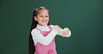 Children, face and happy girl dance in studio with hand movement, fun or playing with music on green background. Smile, dancer and portrait of model with hip hop fantasy motion, steps or competition