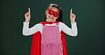 Child, pointing and girl as superhero in studio with halloween promo, info or mockup space. Comic, character and kid in cosplay games as villain with hands to show sale with costume fashion or news