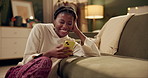 Happy, laugh and black woman with phone on sofa for online chat, communication and networking. Relax, home and person on smartphone for social media, funny website and internet news in living room