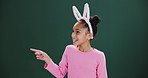 Bunny, girl and child pointing to Easter promotion, announcement in studio or happy in mockup. Holiday, sale and kid show info in dark background, space for news on vacation with fashion or costume