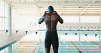 Man, swimmer and preparing at indoor pool for training, exercise or sports for fitness or wellness. Male athlete, healthy and workout with water for cardio at stadium, commitment to swimming or goal
