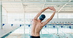 Stretching, back and man with warm up by swimming pool for cardio training, start and preparation. Person, exercise and athlete with flexibility at sports arena for fitness, workout and practice