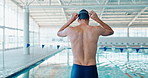 Man, swimmer and preparing at indoor pool for exercise, training or sports for fitness or wellness. Male athlete, healthy and workout with water for cardio at stadium, commitment to swimming or goal