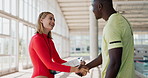Swimming, coach and clipboard with handshake by pool for greeting, collaboration or support. Athlete, people and welcome with discussion at sports arena for progress, evaluation or checklist in Paris