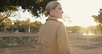 Sunrise, woman and walk for commute city, work and urban area for travel. Rear view, morning and lens flare for corporate female person, professional and outdoor for career and journey to workplace