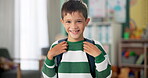 Child, face and laughing in school classroom or education with backpack for kindergarten, learning or joke. Boy, kid and portrait for study development on academy campus or student, humor or funny