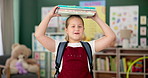 Face, girl and student with books on head, smile and education with knowledge, learning and confident. Portrait, school and kid with fun, playing and childhood development with happiness and cheerful