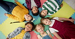 Children, lying down and circle in school with top view for relax, unity and classroom fun on colorful foam mat. Kindergarten, group and happy on floor for education, learning and game for bonding