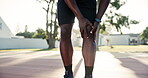 Hands, knee pain and person with injury outdoor at basketball court for exercise, fitness or training accident. Sports, legs and athlete massage muscle for arthritis, fibromyalgia or health problem