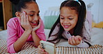 Young girls, phone and smile on bed for learning, entertainment and quality time together at home. Happy, female sisters and mobile in bedroom for development with streaming educational cartoons