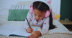 Child, headphones and girl with book in house, music and drawing or writing on bed for childhood development. Growth, creative sketch and education homework, online streaming and audio or listening