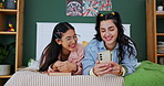 Happy girl, friends and laughing with phone for social media, funny joke or post in bedroom at home. Female person, student or people lying on bed with smile on mobile smartphone for comedy or humor