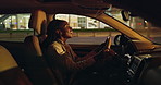 Black woman, driving and singing with car at night for music in cruise, transportation or commute. African, female person or driver enjoying late evening in vehicle for fun travel in an urban town