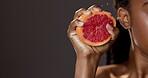 Black woman, hand and grapefruit with health in studio for skincare, detox and beauty with natural product for wellness benefits. Female person, fruit and spa with facial, dermatology or glow results