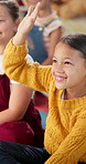 Question, hands up and girl in classroom for answer in lesson, learning and education. Teaching, school and group of young boy and girl students with in reading session for asking, feedback and study