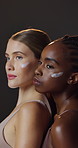 Skincare, face cream and interracial women in studio for natural, health and wellness routine. Beauty, glow and portrait of friends with lotion, spf or sunscreen for dermatology by black background.